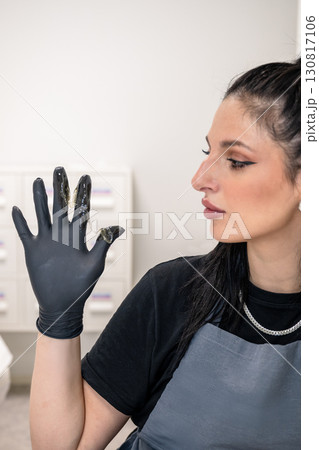 Beautician woman in black gloves holding sugaring paste for professional hair removal Beautician woman in black gloves holding sugaring paste for professional hair removal 130817106