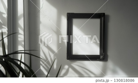 Minimalist black frame with solid white background hanging on white wall in bright room with sunlight Minimalist black frame with solid white background hanging on white wall in bright room with sunlight 130818086