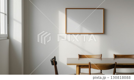 Wooden framed picture with blank white background on a white wall in a sunlit modern dining room Wooden framed picture with blank white background on a white wall in a sunlit modern dining room 130818088