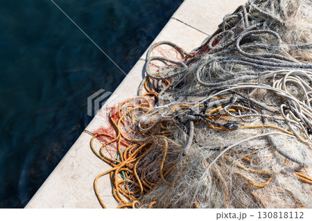 A close-up view of a colorful, tangled fishing net, top view A close-up view of a colorful, tangled fishing net, top view 130818112