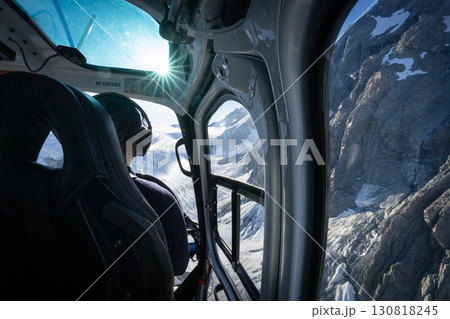 Over the pilot shoulder view from helicopter flying above alpine glacial terrain, New Zealand Over the pilot shoulder view from helicopter flying above alpine glacial terrain, New Zealand 130818245
