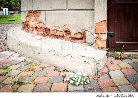 Crumbling facade plaster revealing old damaged brick wall Crumbling facade plaster revealing old damaged brick wall 130818660