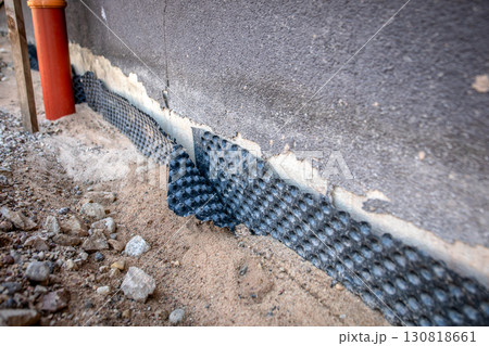 Close-up view of damaged foundation waterproofing membrane during construction 130818661