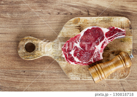 raw rib eye steak, cowboy steak, on a wooden chopping board, top view, no people, raw rib eye steak, cowboy steak, on a wooden chopping board, top view, no people, 130818718