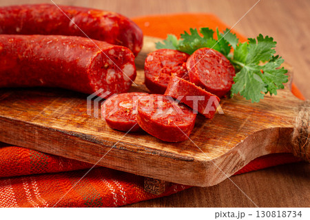 spicy Chorizo sausage, on a cutting board, on a wooden table. 130818734