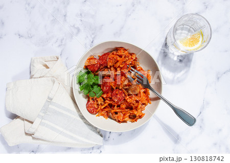 Bigos, Polish dish bigos, on a marble table, stewed meat with cabbage, chorizo sausages, mushrooms, homemade, without people, 130818742