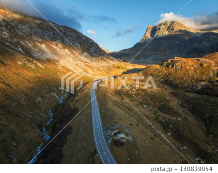 Aerial view of winding road in high alpine valley at sunset 130819054