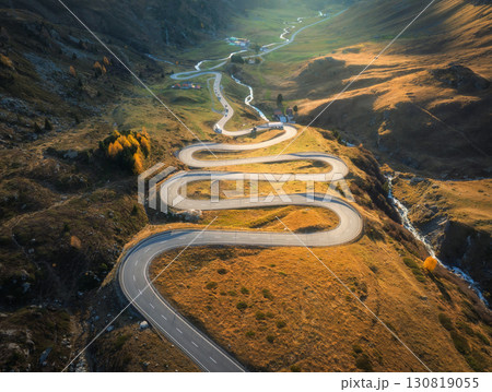 Aerial view of winding mountain road, river in alpine valley Aerial view of winding mountain road, river in alpine valley 130819055