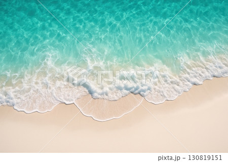 Turquoise waves gently lap against a golden sandy shore under bright sunlight on a serene beach 130819151