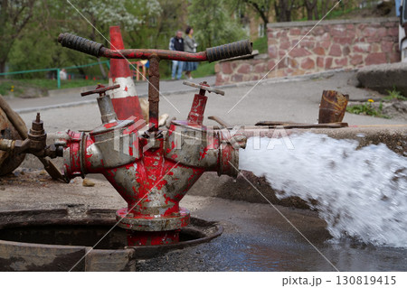 Draining water from building plumbing system. Water flows from faucet and pipe 130819415