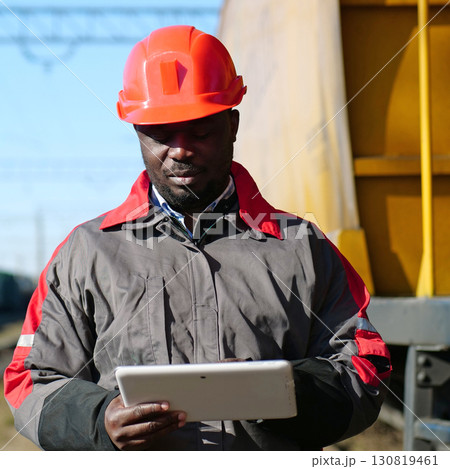 African american railway man with tablet computer at freight train terminal African american railway man with tablet computer at freight train terminal 130819461