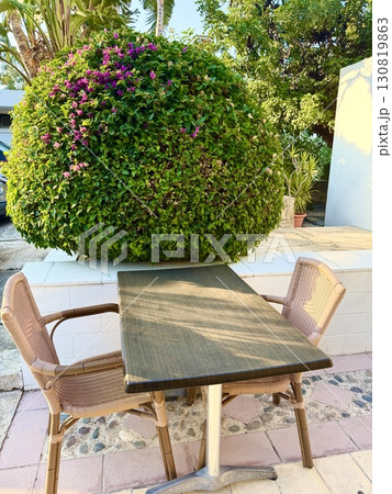 Outdoor seating area with table and chairs. A sunny summer day, a free table outside near the restaurant. 130819863