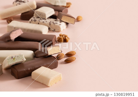 Tasty whey protein bars with various chocolate coatings and sprinkles on pink background. Close up. Copy space. Tasty whey protein bars with various chocolate coatings and sprinkles on pink background. Close up. Copy space. 130819951