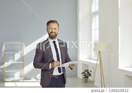 Portrait of happy real estate agent in bright living room of new apartment. 130820012
