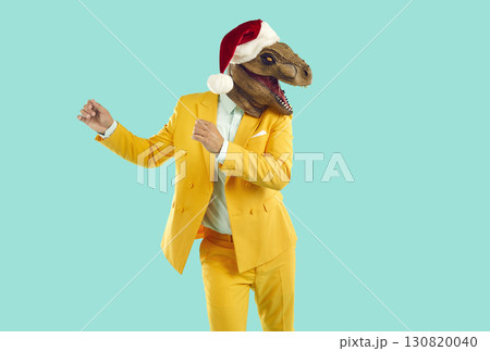 Freaky man with dinosaur head wearing santa hat having fun, happy and dancing at christmas party. Freaky man with dinosaur head wearing santa hat having fun, happy and dancing at christmas party. 130820040