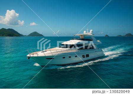 Luxury yacht cruising through clear turquoise waters under a bright blue sky with distant islands 130820049