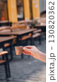 Hand holding a coffee cup in a cozy cafe with blurred background. 130820362