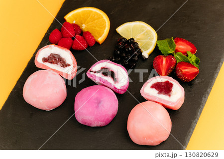 Colorful mochi ice cream with fruity filling on slate board with fresh berries and citrus Colorful mochi ice cream with fruity filling on slate board with fresh berries and citrus 130820629