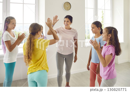 Happy female choreographer rejoicing the success of her students girls in dance training Happy female choreographer rejoicing the success of her students girls in dance training 130820771