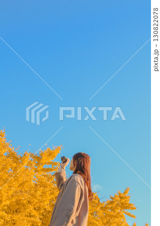 秋の大空とイチョウを撮る女性 秋の大空とイチョウを撮る女性 130822078