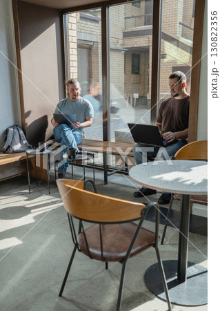 Two knowledgeable professionals collaborating effectively together in a modern workspace setting 130822356