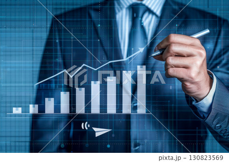 a businessman with pen working on financial graphs, currency symbols, and research notes. a businessman with pen working on financial graphs, currency symbols, and research notes. 130823569