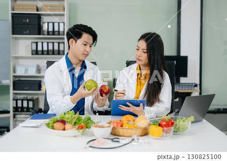 Nutritionists consulting on healthy food choices, meal planning, and wellness concepts Nutritionists consulting on healthy food choices, meal planning, and wellness concepts 130825100