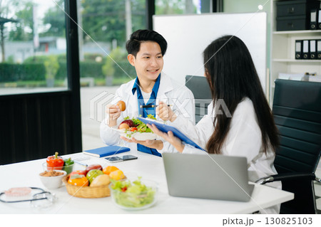 Nutritionists consulting on healthy food choices, meal planning, and wellness concepts Nutritionists consulting on healthy food choices, meal planning, and wellness concepts 130825103