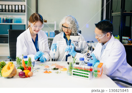 Food scientists in lab coats, testing samples, and analyzing food safety and quality in a modern laboratory 130825845