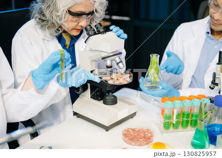 Food scientists in lab coats, testing samples, and analyzing food safety and quality in a modern laboratory 130825957
