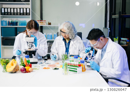 Food scientists in lab coats, testing samples, and analyzing food safety and quality in a modern laboratory 130826047