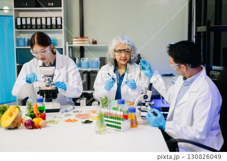 Team Asian scientists in a lab conducting food research using a microscope and lab equipment, showcasing innovation 130826049