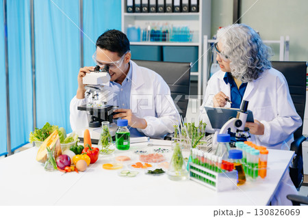 Team Asian scientists in a lab conducting food research using a microscope and lab equipment, showcasing innovation Team Asian scientists in a lab conducting food research using a microscope and lab equipment, showcasing innovation 130826069