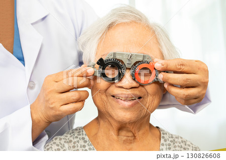 Asian senior woman wearing ophthalmic vision eye test and using optical trial frame. 130826608