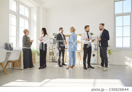 In modern office environment, several diverse groups of professionals interact during workday. 130826644