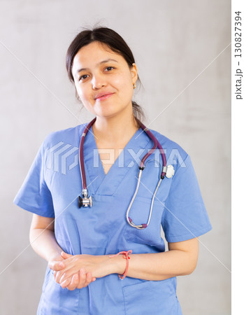 Friendly young female doctor in blue scrub with phonendoscope Friendly young female doctor in blue scrub with phonendoscope 130827394