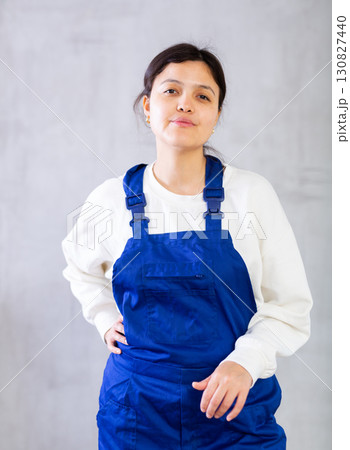 Positive young woman cleaning service worker in blue uniform 130827440