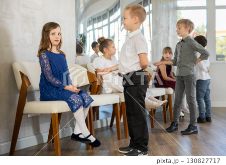 Gentle schoolboys inviting for dance the little girls in events salon Gentle schoolboys inviting for dance the little girls in events salon 130827717