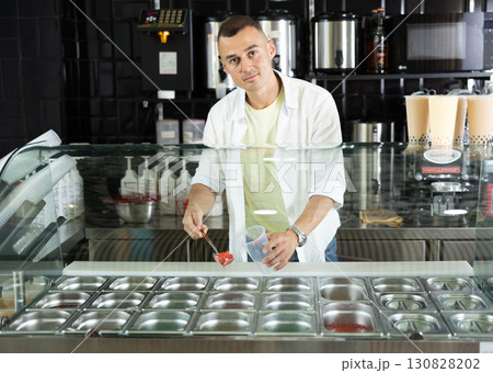 Smiling salesman offering refreshing Taiwanese boba tea Smiling salesman offering refreshing Taiwanese boba tea 130828202
