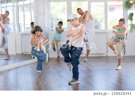 Expressive sports boy learning modern street dancing during group class in choreographic studio 130828341