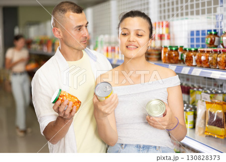 Couple man and woman choose canned food 130828373