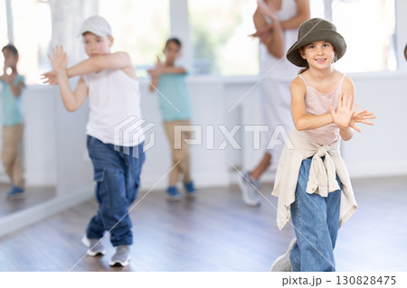 Girls and boys training hip hop in dance studio, dance classes for kids Girls and boys training hip hop in dance studio, dance classes for kids 130828475