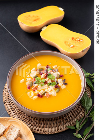 Butternut squash pumpkin soup in a bowl on black background, Homemade food in autumn season Butternut squash pumpkin soup in a bowl on black background, Homemade food in autumn season 130828600