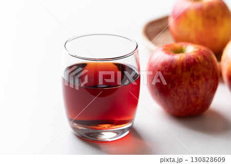 Glass of apple cider with red apple fruit on white background Glass of apple cider with red apple fruit on white background 130828609