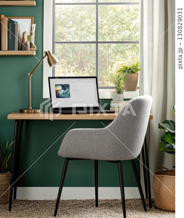 Inviting Home Office Interior With Wooden Desk Laptop and Chair Green Wall Backdrop and Natural Light 130829031