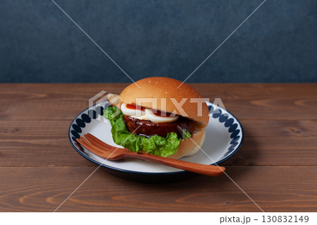 お皿にのせたテリヤキバーガー 木のテーブル 130832149