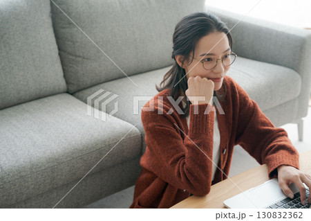 リビングでパソコンの操作をする女性 リビングでパソコンの操作をする女性 130832362