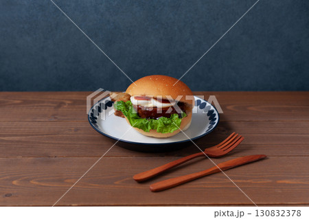 お皿にのせたテリヤキバーガー 木のテーブル 130832378