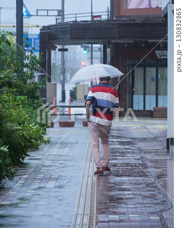 雨の日に高山駅前の街で歩く一人の中年男性の姿 雨の日に高山駅前の街で歩く一人の中年男性の姿 130832865