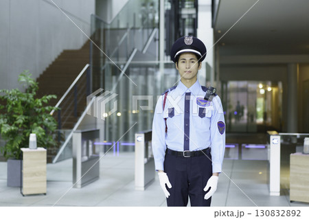 オフィスビルのエントランスロビーに立つ若い警備員　撮影協力:スカパー東京メディアセンター 130832892